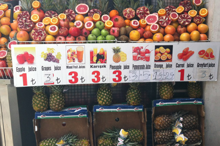 A fruit stand that has several misspelled labels for some of the fruits for sale.